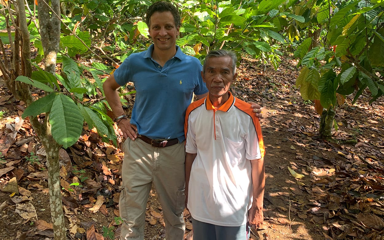 Image shows Nicko Debenham visiting an Indonesian cocoa farmer during his time as a sustainability officer
