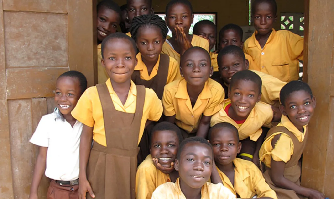 Image shows a groupd of African school children smiling.
