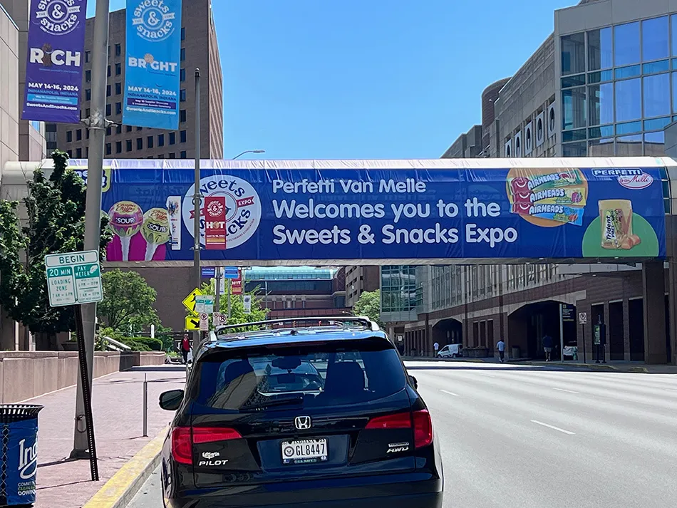 Image shows banner across a street advertising the Sweets & Snacks Expo in Indianapolis.