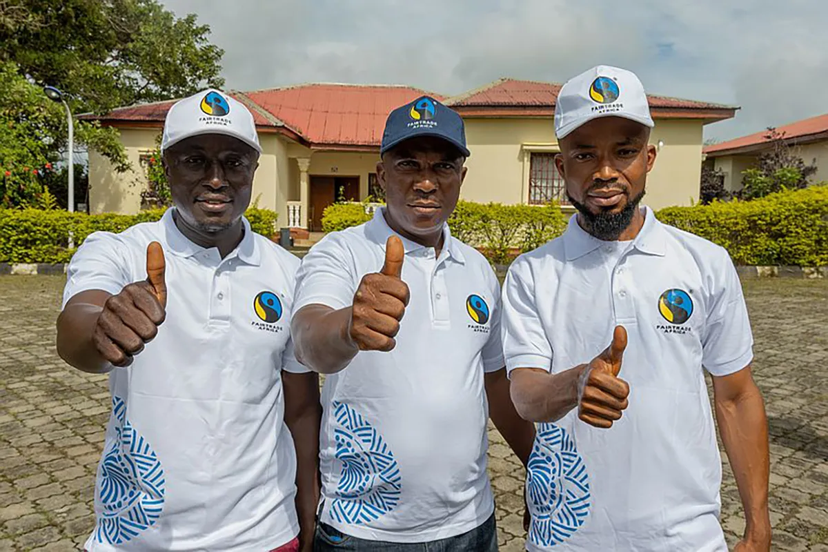 Image shows cocoa farmers in West Africa giving the thumbs up to fair prices.