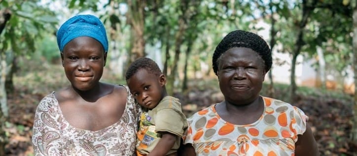 Picture shows two female cocoa farmers and a child in Cote d'Ivoire.